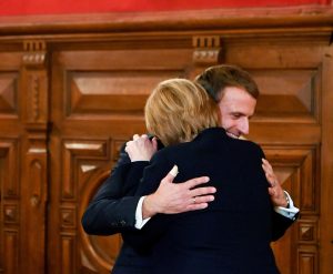 Emmanuel Macron et Angela Merkel s'enlaçant lors des adieux de Merkel