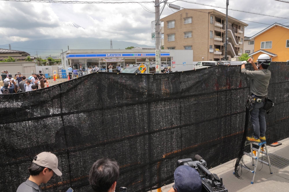  A huge black screen was set up to block a view of Mount Fuji from across a convenience store in Fujikawaguchiko, Yamanashi Prefecture, on May 21. The screen was removed last Thursday.